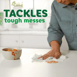 Person cleaning up a mess with text 'TACKLES tough messes' in a kitchen setting.