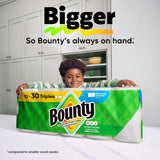 Child holding a large box of Bounty paper towels with text about size comparison.