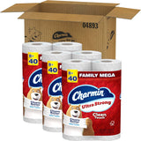 Three packages of Charmin Ultra Strong toilet paper with a cardboard box in the background.