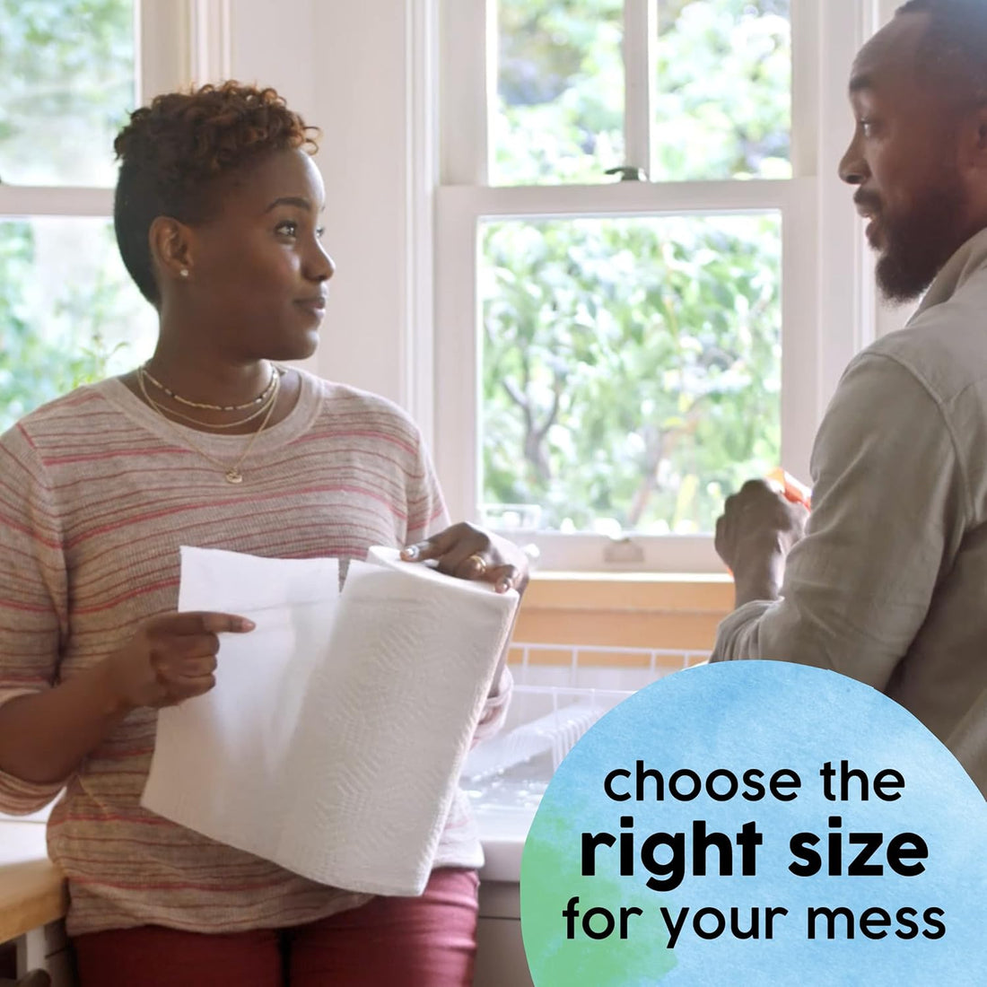 Two people discussing a piece of paper in a bright room with large windows.