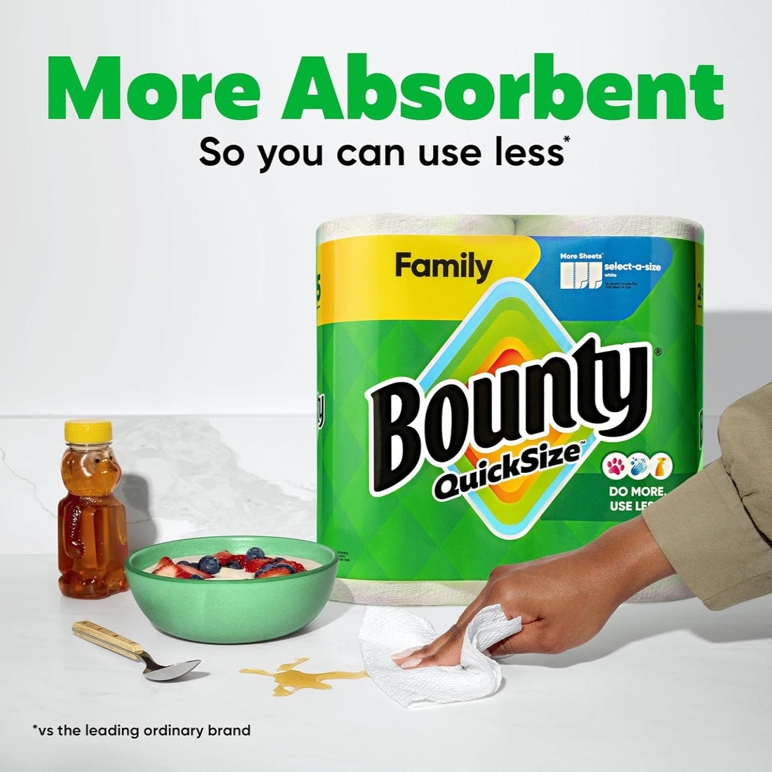 Bounty paper towel package with a hand wiping up a spill, surrounded by a bowl of cereal and honey.