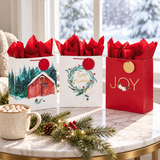Hallmark Christmas gift bags (Wreath, Gold Joy, Red Barn) with red tissue by a snowy window